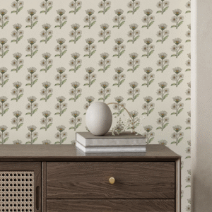 Zoomed-in of Retro Whimsy Daisy peel and stick wallpaper with beige and olive hand-drawn daisy motifs behind a dark wood sideboard with rattan detail and stacked books