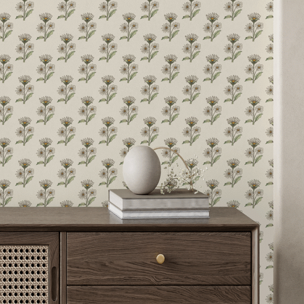 Zoomed-in of Retro Whimsy Daisy peel and stick wallpaper with beige and olive hand-drawn daisy motifs behind a dark wood sideboard with rattan detail and stacked books