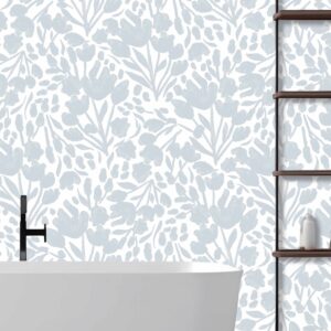 This is a zoomed-in delicate blue floral wallpaper in a serene bathroom setting with a freestanding white tub and wooden shelving