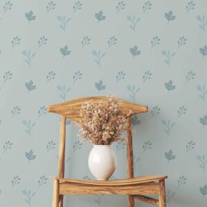 A zoomed-in minimalist wooden chair against light blue floral wall covering