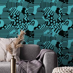 Here for a Good Time peel and stick wallpaper with bold black and cyan abstract shapes behind a modern grey sofa and textured throw