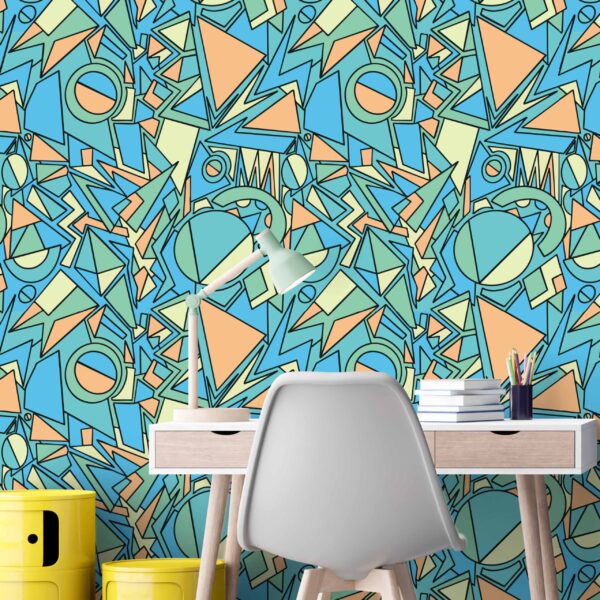 Colourful abstract peel and stick wallpaper featuring angular industrial shapes behind a child’s desk in a playful bedroom