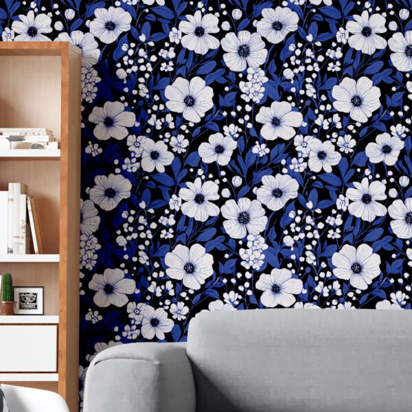 A zoomed-in moody blues and ivory blossoms behind a beige headboard and nightstand with ceramic décor