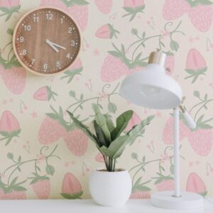 A Close-up of pink strawberry wallpaper behind wooden clock and plant