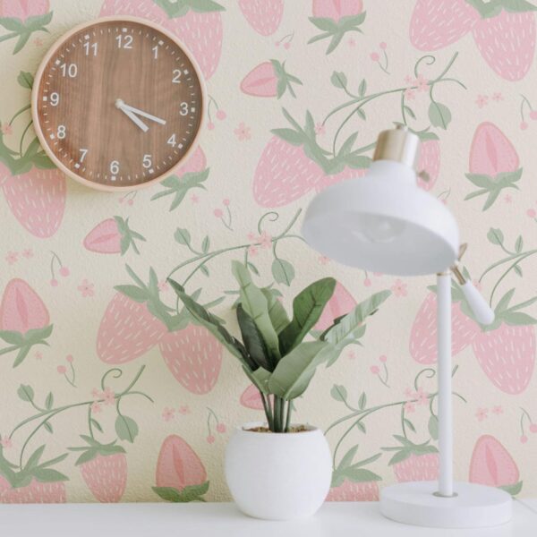 A Close-up of pink strawberry wallpaper behind wooden clock and plant