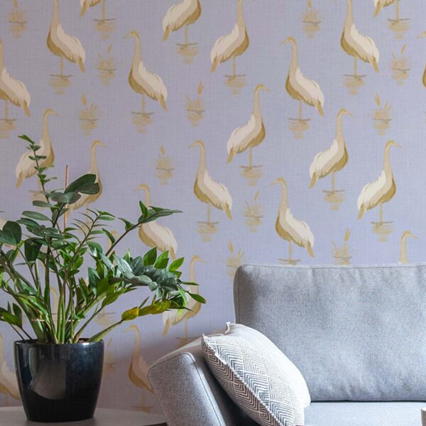 A zoomed-in heron-themed wallpaper in a serene lavender setting behind modern grey couch