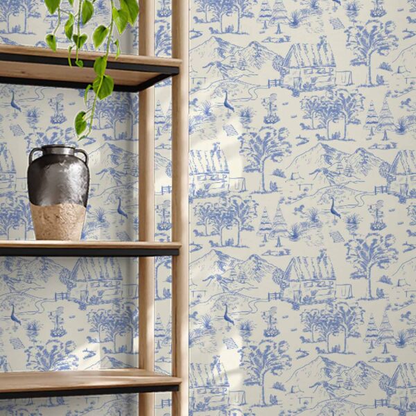 French-inspired Toile et Plume wallpaper styled behind a rustic wooden bookshelf in a warm-toned interior