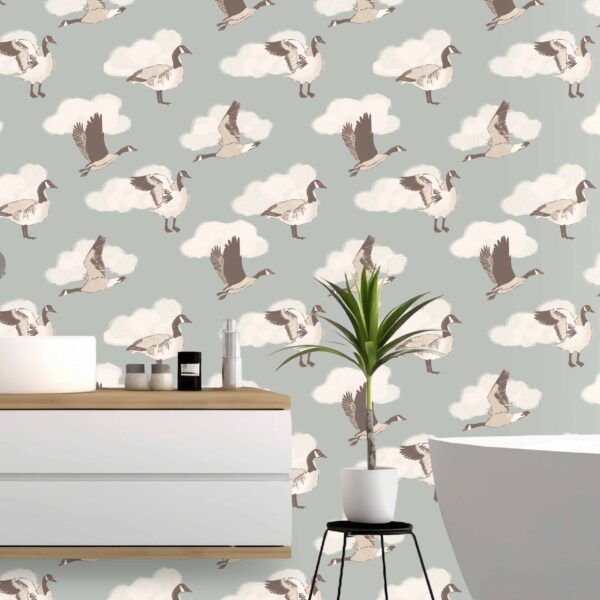 A zoomed-in Canada goose peel and stick wallpaper with whimsical birds in flight and soft white clouds, styled in a spa-like bathroom with wood vanity and modern tub