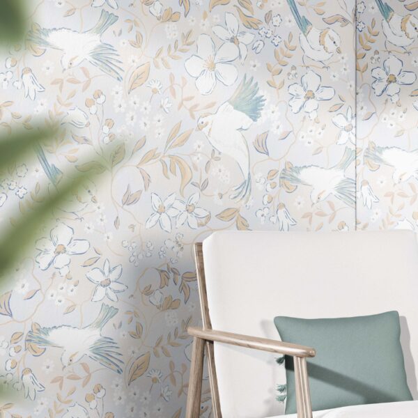 A zoomed-in charming wallpaper with flying birds and subtle floral accents in beige and teal tones behind a white lounge chair with wooden arms and green cushion