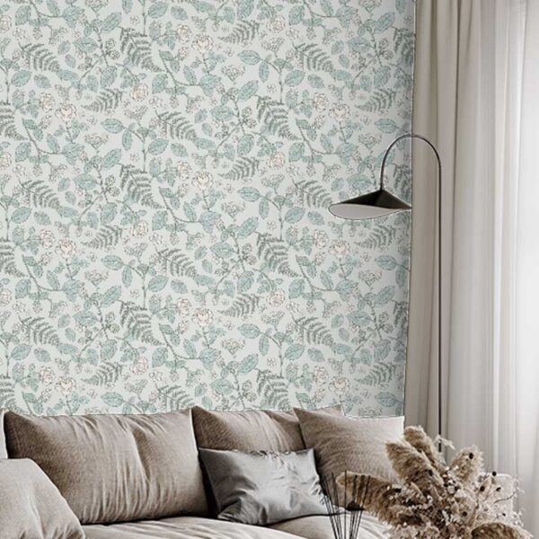 A zoomed-in elegant botanical wallpaper behind a modern beige sectional sofa
