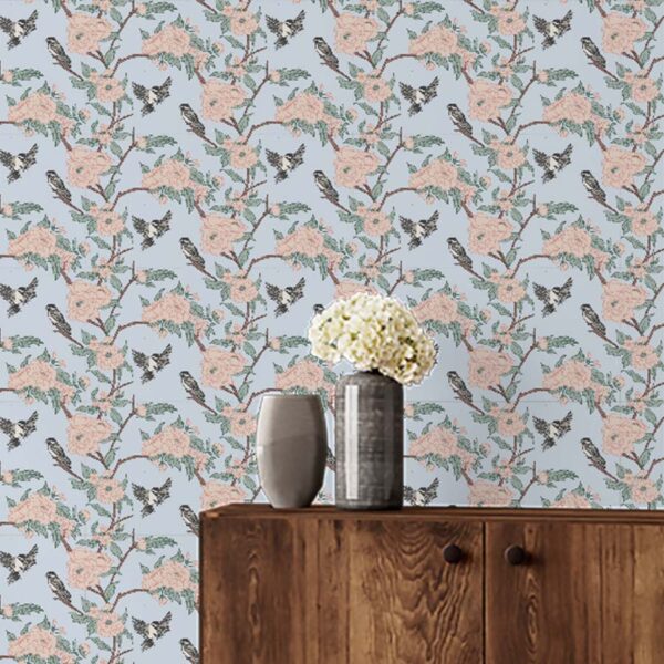 A zoomed-in of Chickadee & Bloom wallpaper in sage green with white flowers and perched birds in a minimalist space