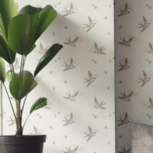 A zoomed-in Elegant bird motif wallpaper in a neutral-toned living space with modern grey seating and indoor plant.