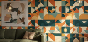 A zoomed-in of Geo mural displayed behind a green sofa with warm lighting, showcasing layered geometric forms and a mid-century color palette.