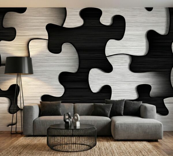 Black and white jigsaw wallpaper with interlocking puzzle shapes, styled behind a grey sectional sofa in a modern living room.