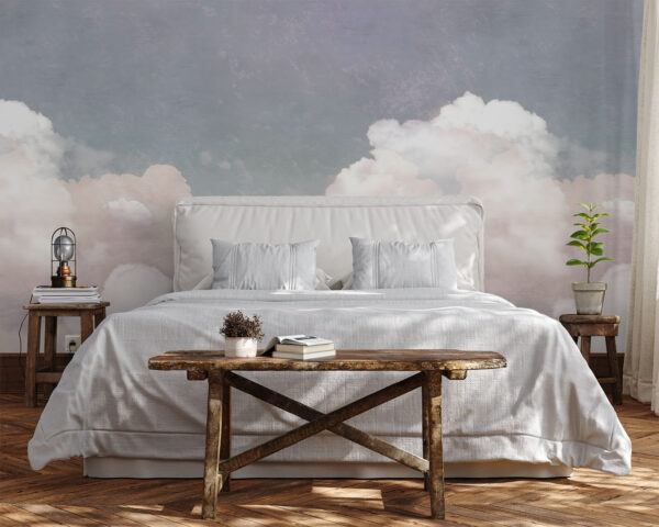Cloudy Dusk mural styled behind a bed with dreamy clouds in muted pink and grey creating a calm bedroom atmosphere.