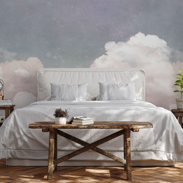 Cloudy Dusk mural styled behind a bed with dreamy clouds in muted pink and grey creating a calm bedroom atmosphere.
