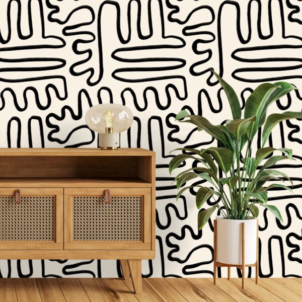 A zoomed-in Painter’s Doodle wallpaper styled in a modern space with organic black line pattern and indoor plant.