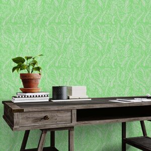 A zoomed-in foliage wallpaper with delicate white leaf illustrations styled behind a wooden desk and plant.