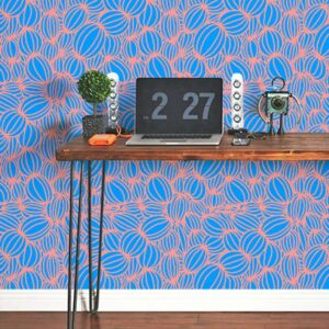 A zoomed-in of we’re All Connected wallpaper with coral looping lines forming organic shapes on a bright blue background behind a desk.