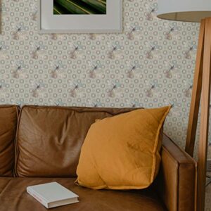 Dragonfly wallpaper styled behind a brown leather sofa with geometric pattern and delicate dragonflies on a soft neutral background
