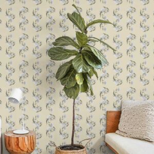 Flowery Hardwick White wallpaper behind a potted plant and wooden side table in a cozy bedroom corner