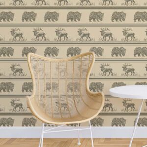 Fur & Hide wallpaper styled with a woven chair and table featuring horizontal rows of bears and deer on a warm beige background