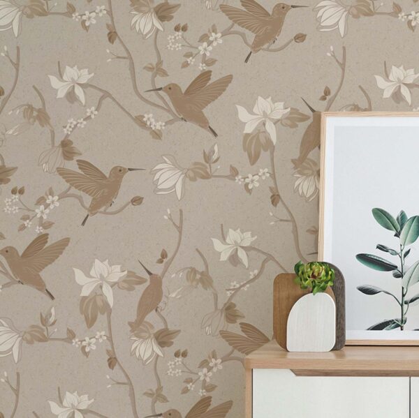 Guilded Fusion Chinoiserie wallpaper in Golden Mist featuring hummingbirds and floral branches on a warm beige background in a modern bedroom
