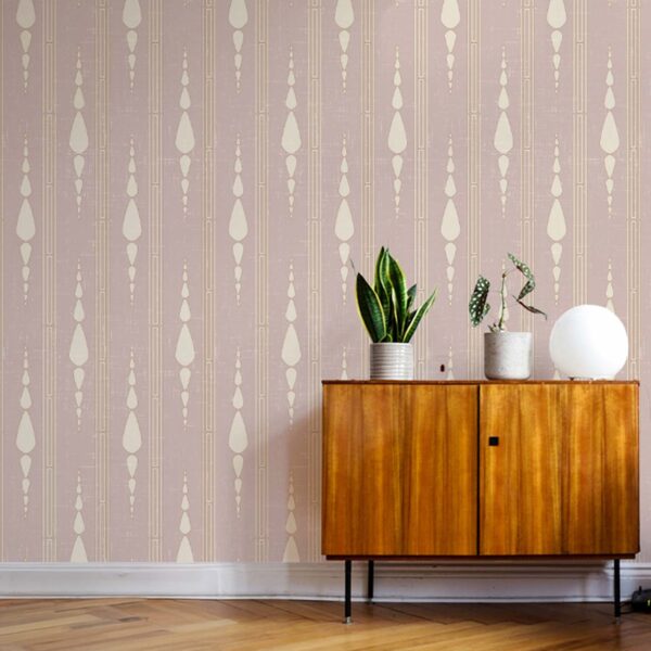 The Garden Room Wallpaper in Dusty Blush with geometric vertical pattern behind a wooden cabinet and potted plants